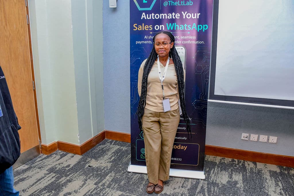 An attendee beside a partner stand in the session room