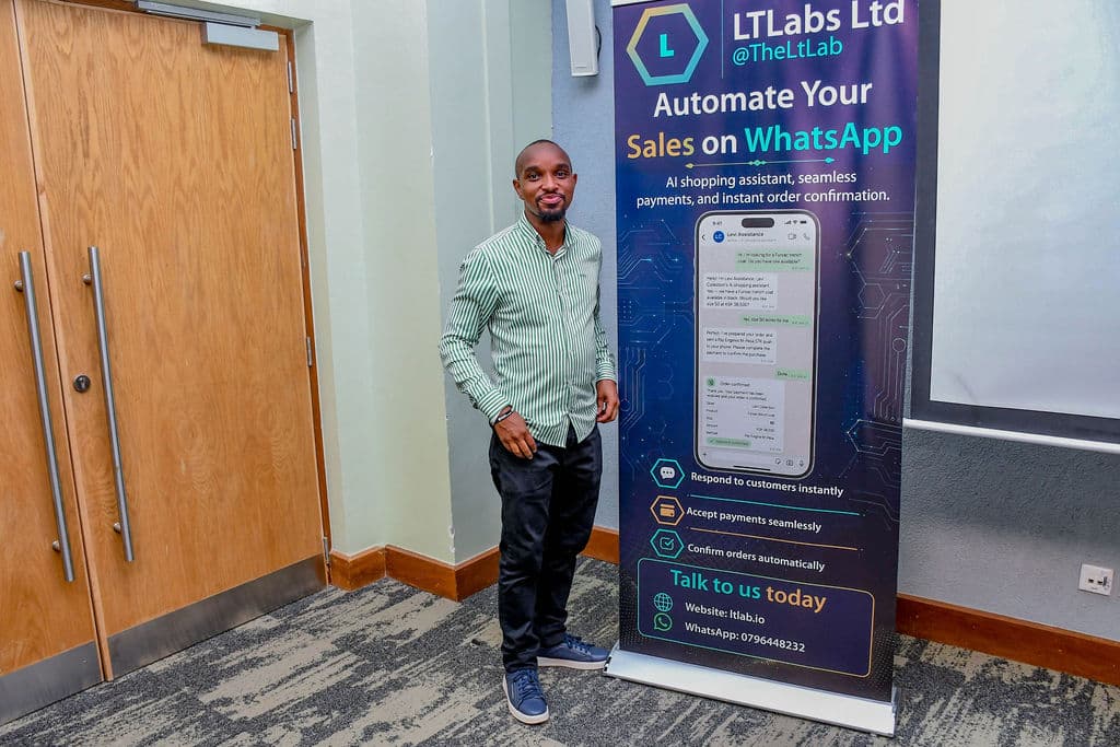 An attendee beside a partner stand near the session room